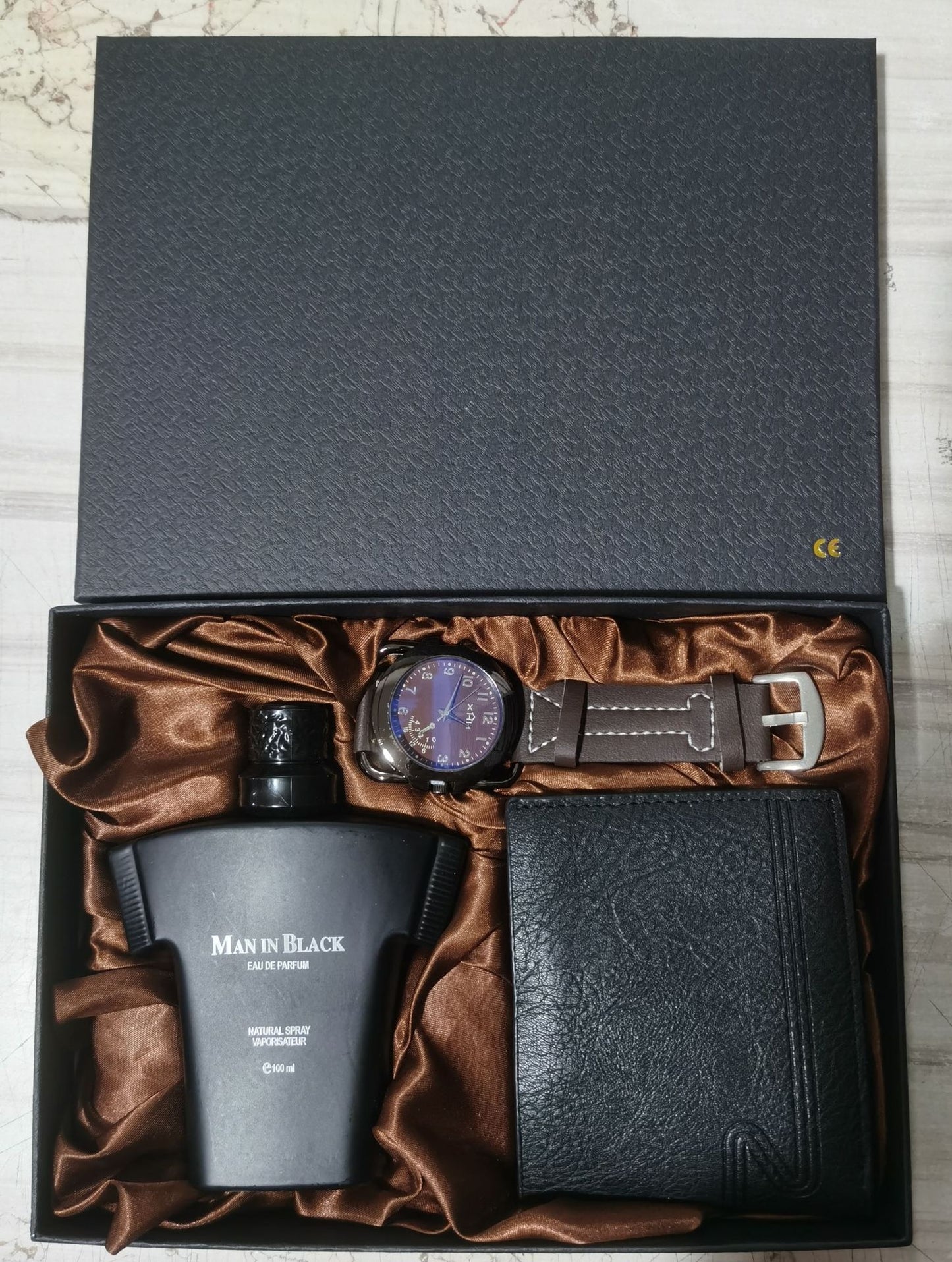Luxury gift set with Man in Black perfume, brown leather strap wristwatch, and black leather wallet in satin-lined box