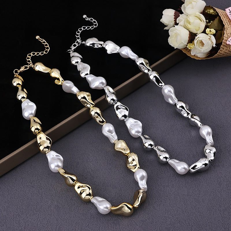Two elegant beaded necklaces with irregular gold and silver beads paired with white pearls on a gray surface with white flowers