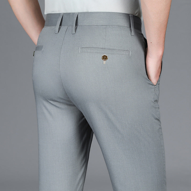 Close-up of man wearing light gray slim-fit dress pants with buttoned back pocket and side pockets