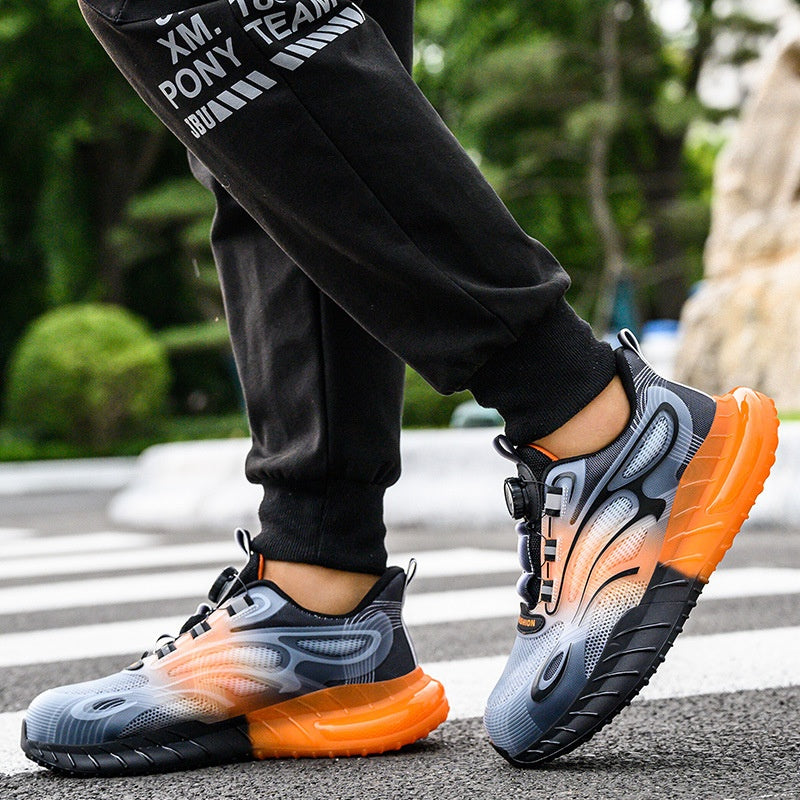 Modern men's athletic sneakers with orange and black gradient sole, worn with black jogger pants outdoors