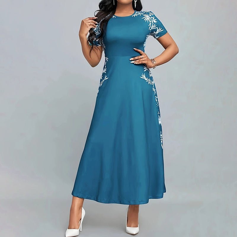 Woman wearing elegant teal short sleeve maxi dress with white floral embroidery and white heels