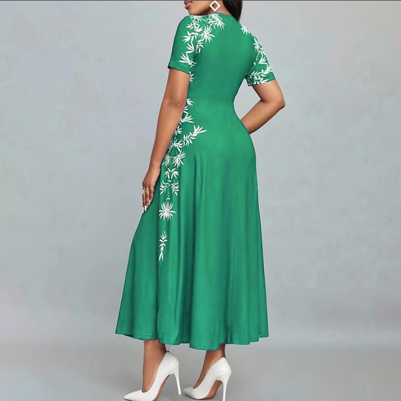 Woman wearing green short sleeve empire waist maxi dress with white floral print and white high heels
