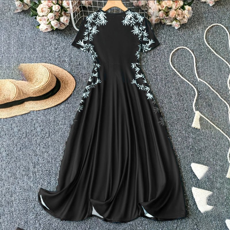 Elegant black short sleeve maxi dress with white floral embroidery, styled with straw hat and flowers