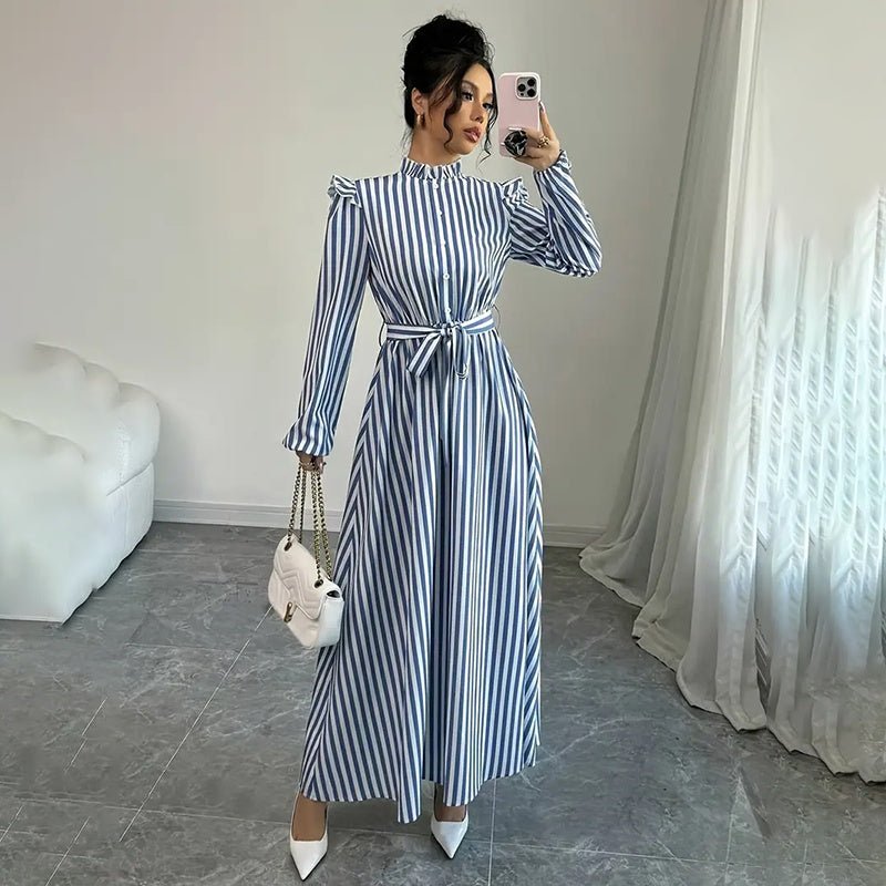 Woman taking selfie wearing blue and white vertical striped long sleeve maxi dress with belt and ruffled shoulders