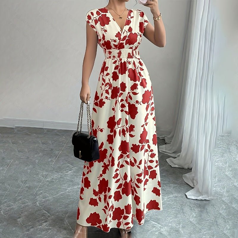 Woman in white maxi dress with red floral print, V-neck, short sleeves, and elastic waist holding black purse