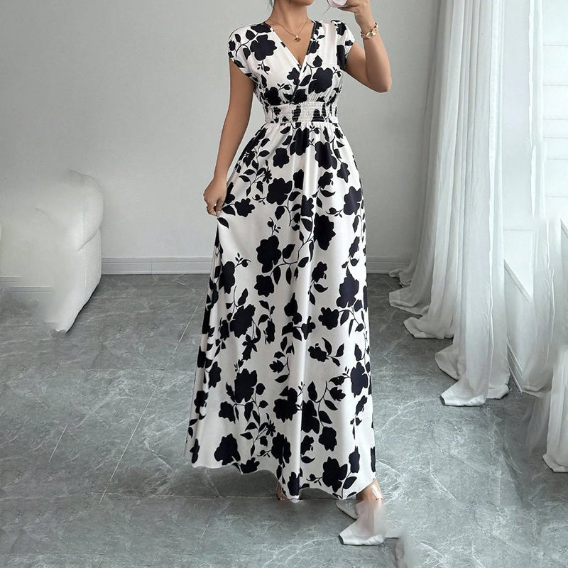 Woman wearing black and white floral wrap maxi dress with short sleeves and elastic empire waist